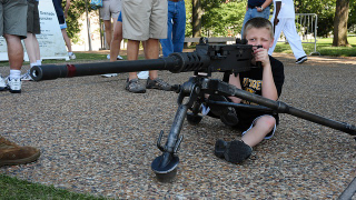 Illustration for article titled For Some Reason, Adorable Kids Are Holding Big Ass Guns